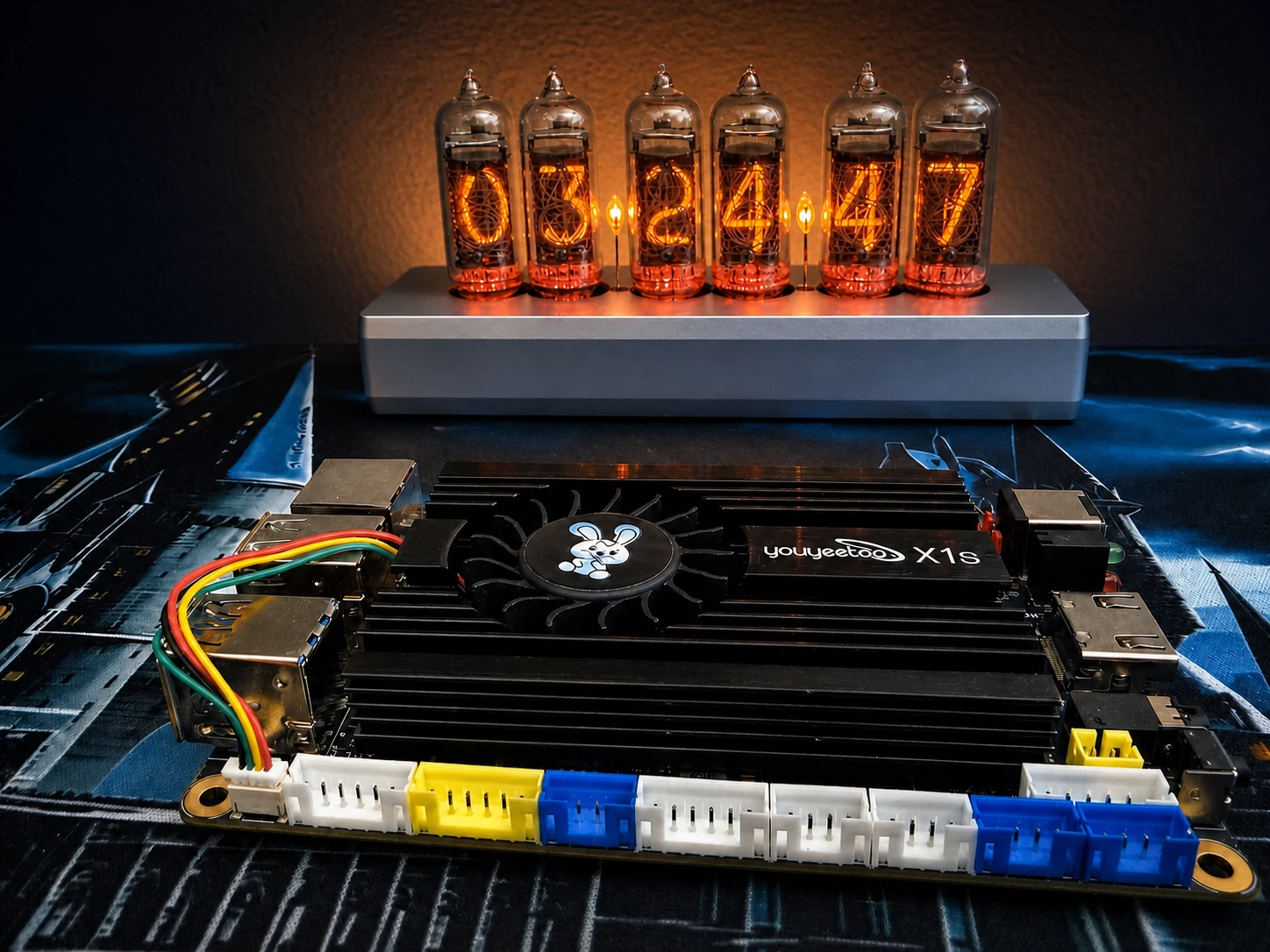 Youyeetoo X1S on the workbench with its heatsink and active fan visible in front of a glowing Nixie clock