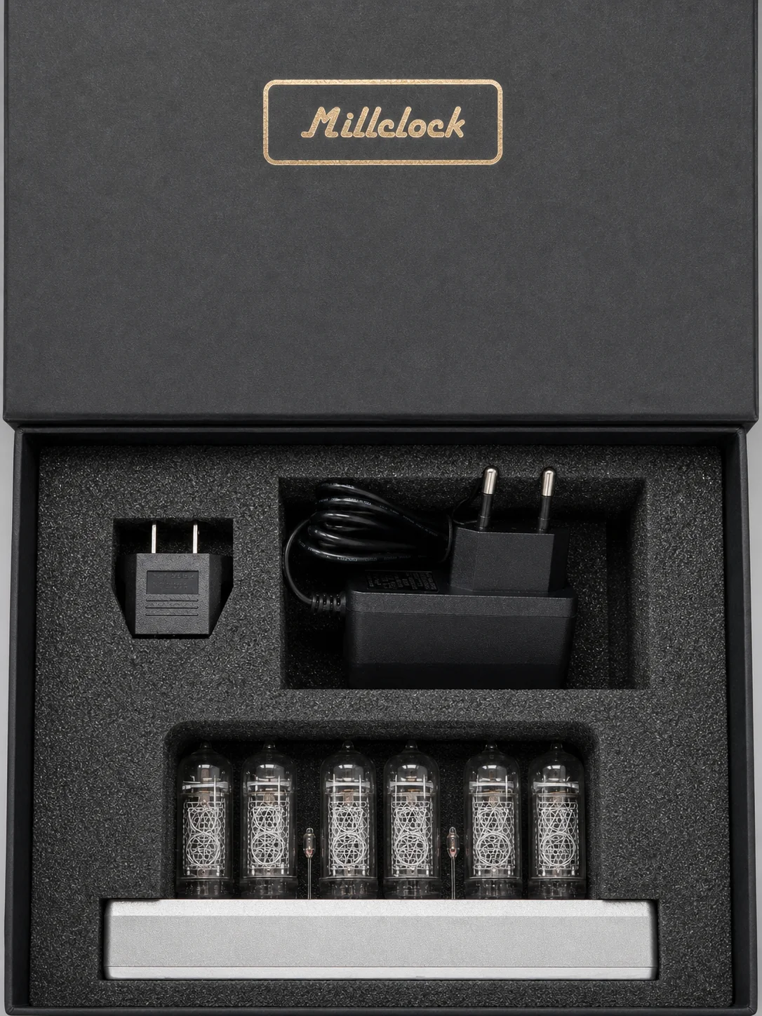Millclock IN-14 clock and power accessories arranged in fitted black foam packaging
